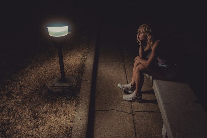 woman in black tank top sitting on concrete floor