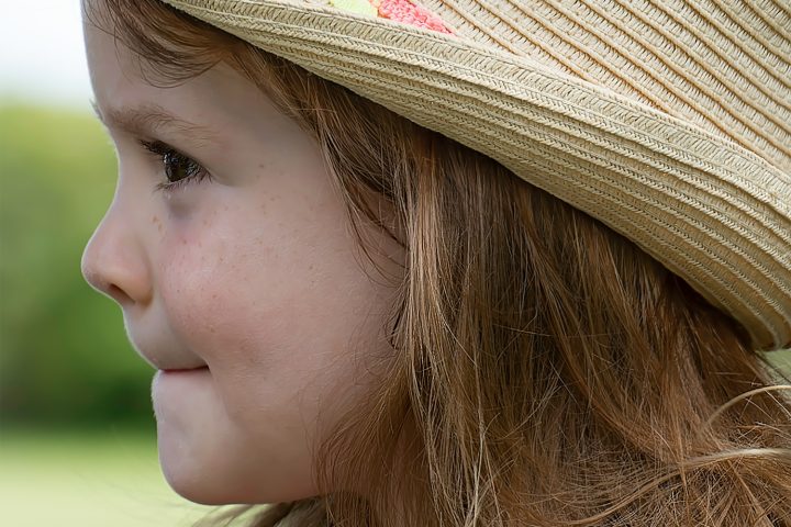 a little girl with a hat on her head