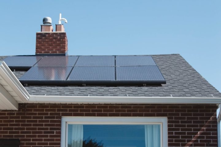 brown brick house with solar panels on roof